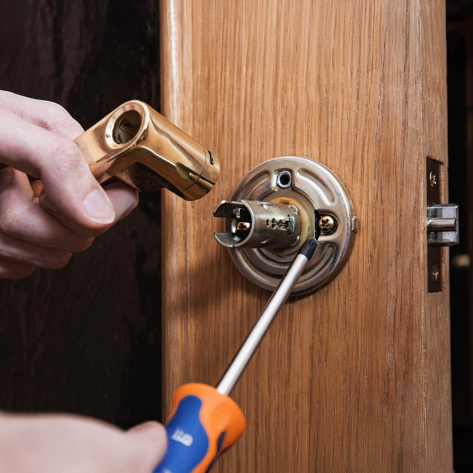 Locksmith installing a lock at a homeowners house