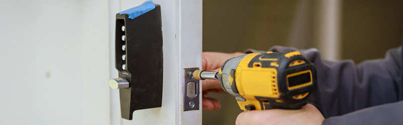 Hand unlocking a residential door with a key during a lock service in Aurora Colorado